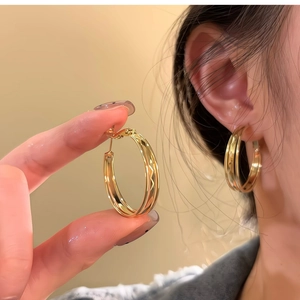 Macro shot of gold double-hoop earrings featuring intricate diamond-cut textured surfaces
