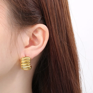 Macro shot of gold-plated stainless steel ribbed earring with textured ripple design