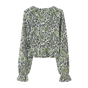 Close-up of paisley print chiffon blouse with ruffle cuffs and intricate green floral details