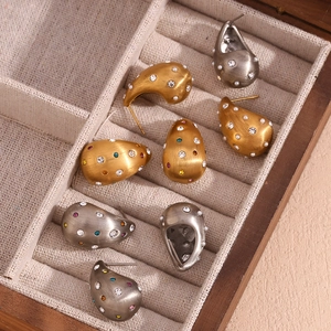 Vue macro de boucles d'oreilles goutte mates avec cristaux et perles en bois