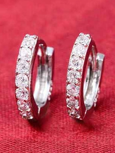Macro shot of silver metal hoop earrings with sparkling white cubic zirconia pavé
