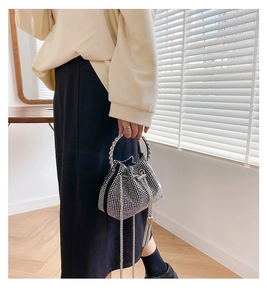 Detailed view of silver drawstring bucket bag with rhinestones and metal ring handle