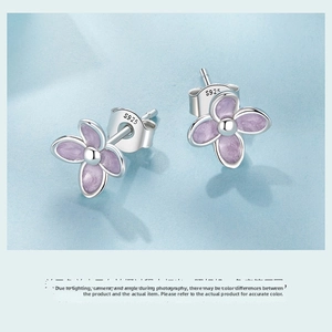 Macro detail of S925 sterling silver lilac flower studs with purple enamel petals