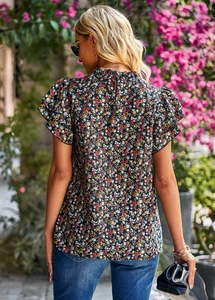 Detail view of floral print blouse featuring a ruffled sleeve and back button closure