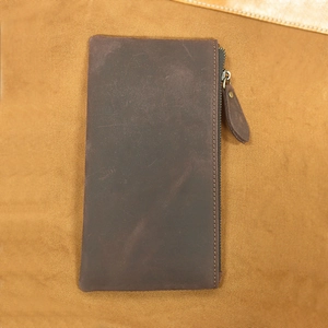 Macro detail of dark brown crazy horse leather wallet with vintage metal zipper