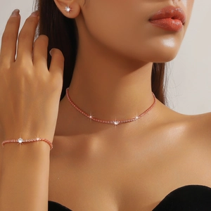 Close-up of elegant rose gold bridal jewelry set with round cubic zirconia on model