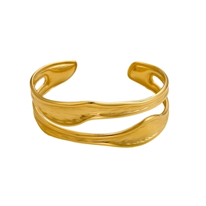 Detail of artistic golden open cuff bracelet featuring double-layer wave design and texture