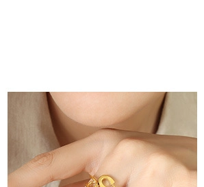 Close-up of a minimalist golden chain design ring worn on a finger with professional lighting