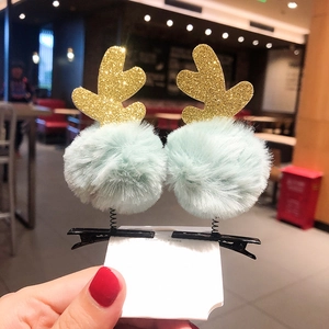 Detail shot of gold glitter reindeer horn hair clips with soft light blue plush pom-poms