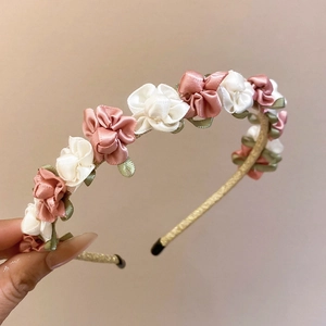 Detailed macro view of handmade fabric rose floral headband with elegant silk petals