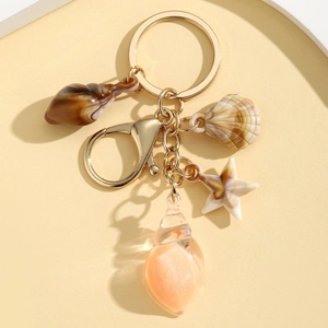 Detailed view of glow-in-the-dark conch starfish keychains with golden metal ring and D-clasp
