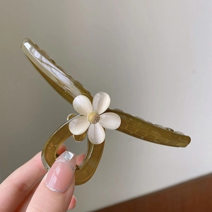 Detailed view of large olive green hair claw clip with a glossy white resin flower