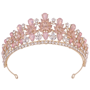 Close-up of elegant gold alloy tiara with pink and white crystals in floral design