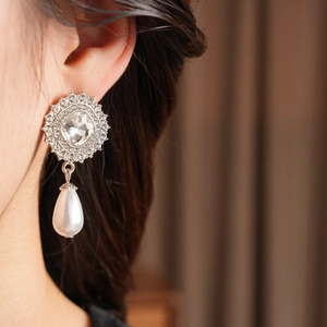 Close-up of a vintage crystal pearl drop earring worn by a model in soft lighting