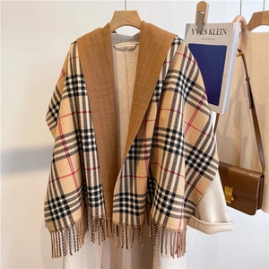 Detail of soft cashmere-like scarf showing brown and beige plaid pattern with fringe