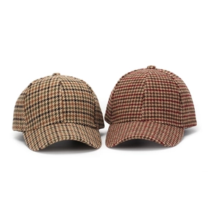 Detailed view of houndstooth plaid baseball caps in brown and reddish textured fabric