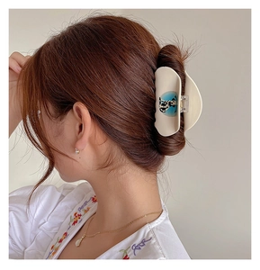 Detailed view of a white acetate cherry rhinestone hair claw clip on female hair
