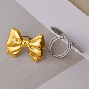 Macro view of gold and silver bow rings with high-polish finish on geometric background
