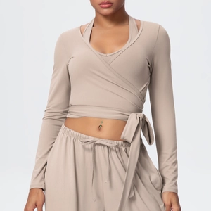 Detail of almond yoga set featuring a wrap-around tie waist and soft brushed fabric texture