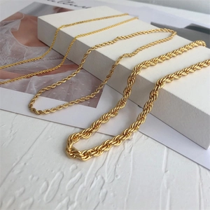 Detalle de cuatro grosores diferentes de collares de cadena de cuerda de acero dorado