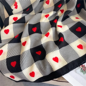 Close-up of lightweight checkerboard scarf with red heart pattern and fine stripes
