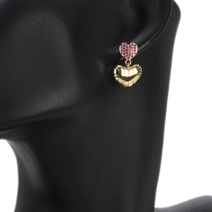 Detail of pink zircon heart stud and golden textured heart pendant on a model