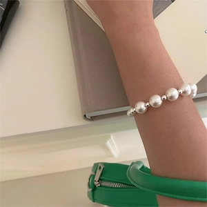Detailed close-up of 925 sterling silver pearl bracelet worn on wrist for an elegant style