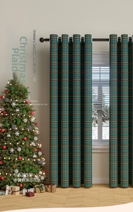 Detailed texture of red and green plaid Christmas curtains with festive pom pom trim