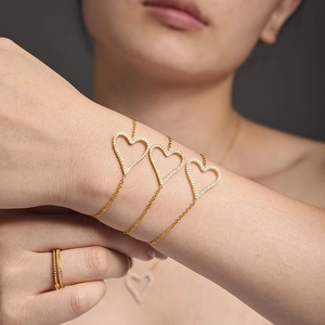 Elegant gold heart jewelry set featuring micro-paved crystal necklace and bracelet on model