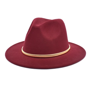 Detail of burgundy wool fedora hat featuring a gold metallic textured decorative band