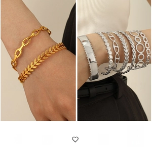 Detail of vintage Cuban chain and chunky C-shaped bangles in gold and silver finish