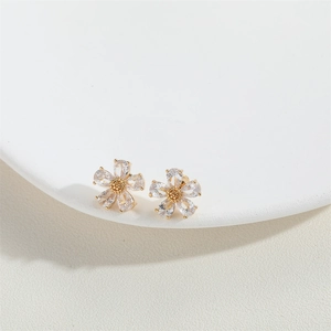 Close-up of elegant flower stud earrings with gold base and sparkling zircon petals