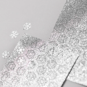 Detail von silbernen Glitzer-Nagelstickern mit Schneeflocken- und Rentier-Motiven