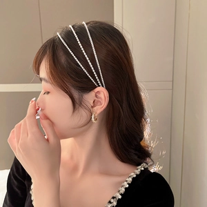 Gros plan d'un serre-tête à perles triple rang et de boucles d'oreilles dorées assorties