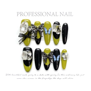 Handmade almond press-on nails with avocado green, black lace bows and silver crystal butterfly