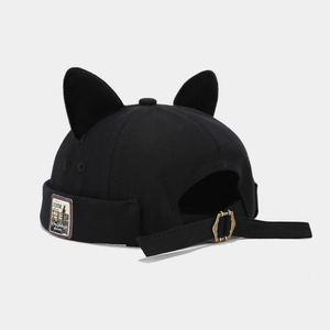 Detail of black cat ear beanie with vintage woven label and adjustable metal buckle strap