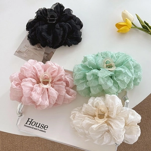 Detail of oversized layered bow hair claws in black pink green and cream organza