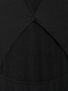 Gros plan sur la texture plissée noire et les coutures croisées d'une robe de mode