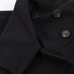 Gros plan détaillé du tissu en laine noire de qualité et des boutons du manteau
