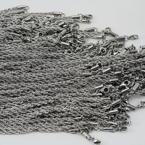 Detailed close-up of stacked silver stainless steel twisted rope chains with lobster clasps