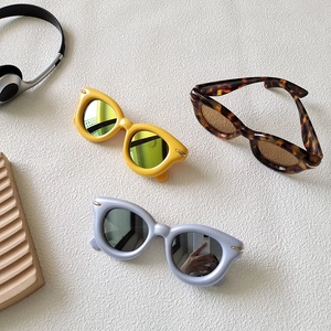 Close-up of retro oval sunglasses with thick frames and metal stud details in various colors
