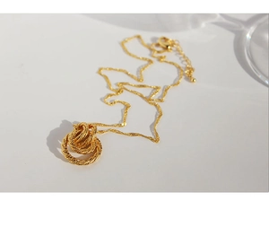 Detail of vintage gold twisted interlocking rings pendant and delicate link chain