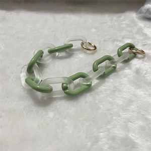 Detail of acrylic green and frosted transparent chain links with golden metal rings