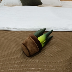 Détail d'un cactus en peluche doux aux feuilles vertes sur une couverture brune