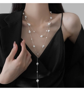 Baroque pearl beaded Y-necklace layered over a black blazer for an elegant style
