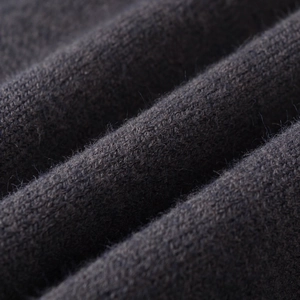 Close-up of charcoal grey knit fabric with soft puff sleeves and high neck texture