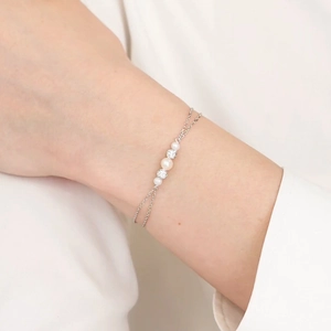 Detail of a double-layer S925 silver bracelet featuring elegant pearls and zircon accents