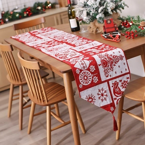 Christmas knitted table runner with reindeer pattern and tassels on wooden table