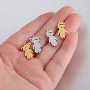 Polished stainless steel boy and girl charms in gold and silver finish on palm