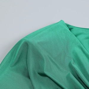 Dettaglio del tessuto a maglia verde smeraldo con eleganti effetti di drappeggio